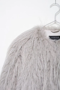 Detail shot of light grey faux fur texture on a minimalist lapel coat with soft fibers