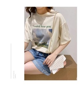 Detail of a chic plaid chain bag with pink flap and stylish graphic print white t-shirt