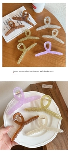Macro view showing various colors of acrylic hair claw clips in minimalist Korean style