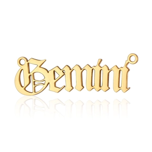 Polished gold Gemini zodiac pendant with gothic font and clear reflection on white backdrop