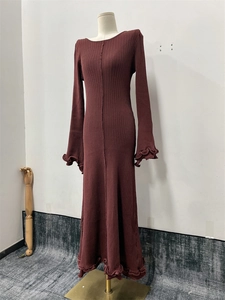 Detail of burgundy ribbed knit dress showing lettuce edge hem and ruffled trumpet sleeves