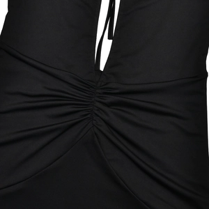 Détail de la robe noire avec décolleté en V profond, lacets et texture froncée