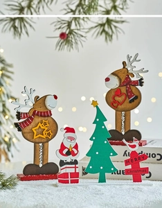 Detailed view of wooden reindeer and Santa Claus figurines on a snowy festive background