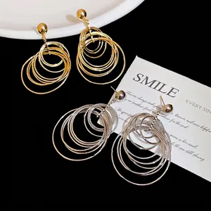 Chic multi-layered circular drop earrings in gold and silver finish on a dark background