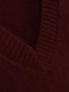 Macro shot of V-neck stitching and wine red knitted texture of the wool sweater