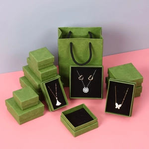 Detail of vintage green embossed jewelry boxes and matching gift bags with clover necklaces