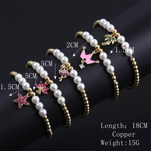 Détail de cinq bracelets en perles avec breloques flamant rose, couronne et palmier