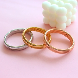 Detailed macro view of flexible cobra bone bracelets in silver, gold and rose gold tones