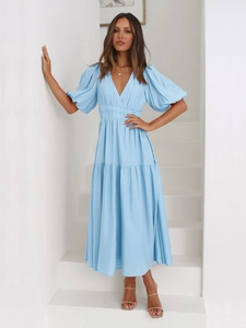 Detail of light blue tiered maxi dress with puff sleeves and deep V-neckline