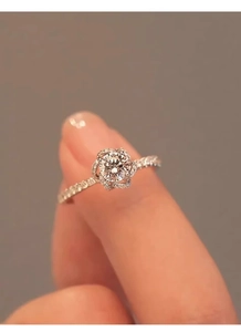 Detailed close-up of a floral halo diamond ring featuring a sparkling round center stone