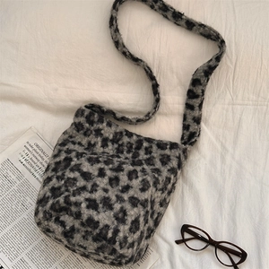 Flat lay of leopard print plush shoulder bag with newspaper and glasses decorations