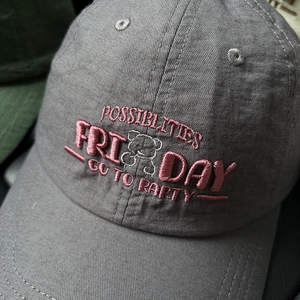 Detail of pink 3D letter embroidery and bear pattern on a grey cotton baseball cap