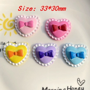 Detailed view of colorful resin bow-knot charms for DIY phone cases and accessories