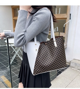 Close-up of a large-capacity tote bag with white leather and brown geometric canvas stitching