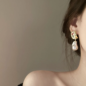 Close-up of vintage baroque pearl earrings with floral enamel details on model