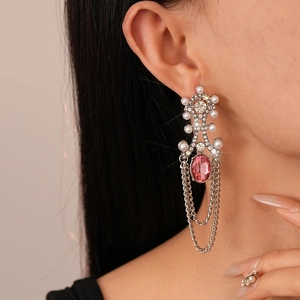 Vintage geometric tassel earrings with pearls and pink gems on elegant model