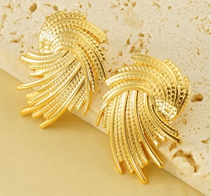 Macro detail of gold spiral earrings with mixed smooth and textured woven patterns