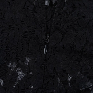 Macro detail of the floral lace pattern and concealed zipper on a black evening gown