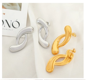 Detailed view of irregular geometric S-shaped hoop earrings in gold and silver finish