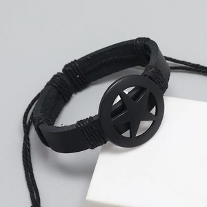 Macro detail of black leather punk bracelet featuring matte metal pentagram and woven rope