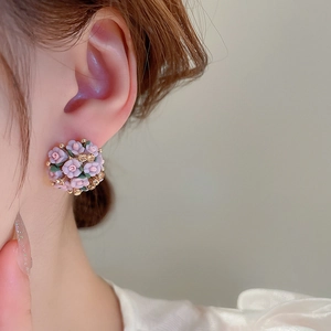 Close-up of pink flower cluster earrings with rhinestones on model's ear