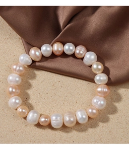 Detail showing natural white and pink freshwater pearls with silk texture background