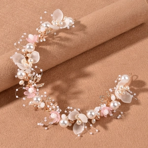 Close-up of handmade bridal headband with gold wires, white pearls and floral detail