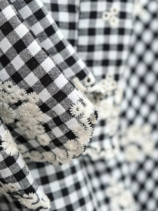 Détail de tissu à carreaux noir et blanc avec broderie florale haut de gamme