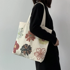 Close-up of a canvas tote bag with colorful hand-painted floral art and spacious design