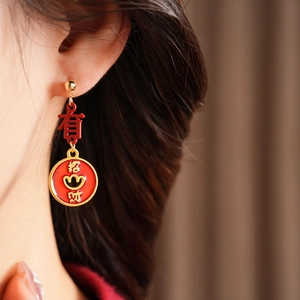 Detail of vintage enamel red and gold tassel earrings with Chinese fortune characters