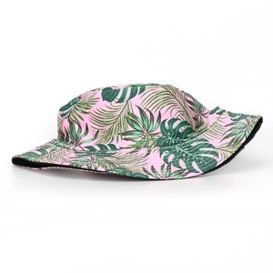 Detail of pink tropical bucket hat with green monstera and palm leaf prints