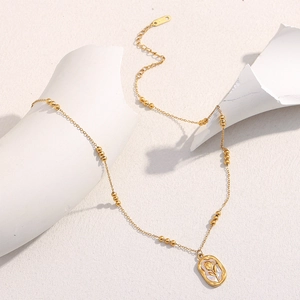Detail of 18K gold plated necklace featuring a rose pendant and beaded pearl chain