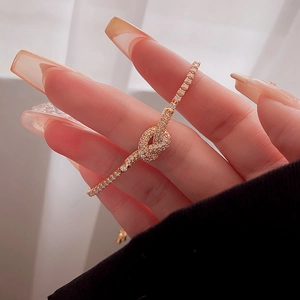 Macro view of knot design bracelet with sparkling zircon pavé in rose gold plating