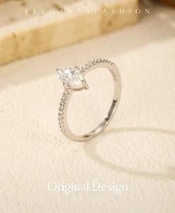 Detailed macro shot of a marquise cut moissanite silver ring on a textured stone base