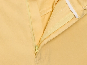 Détail du zip et des coutures sur le pantalon large jaune pour femme