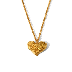 Macro shot of gold stainless steel heart pendant with unique crinkled metal texture