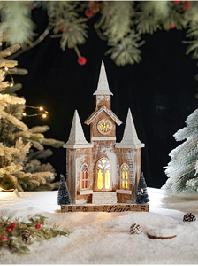 Detailed close-up of a wooden Christmas church with warm LED lighting and snow texture