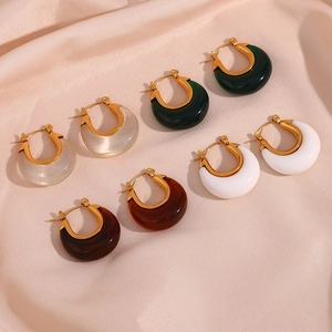 Set of four pairs of vintage resin hoop earrings in assorted colors on silk background