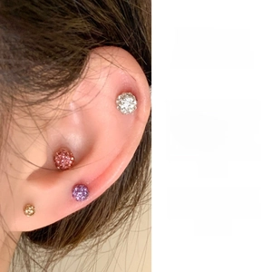 Detailed close-up of colorful 3-6mm titanium steel screw-back ball studs on ear