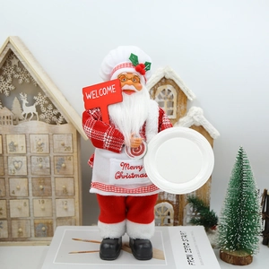 Détail d'une figurine de Père Noël cuisinier avec panneau de bienvenue et plateau de Noël