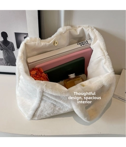 Intérieur spacieux du sac seau en peluche blanche montrant le rangement et fermoir doré