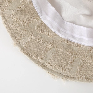 Close-up of the beige bucket hat showing fringed edges and breathable mesh lining