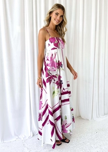 Detailed close-up of white summer maxi dress with purple floral patterns and spaghetti straps