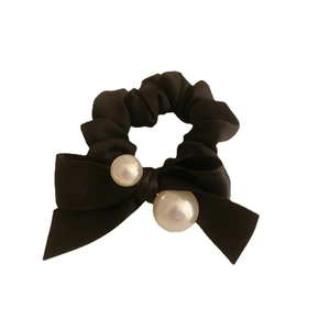 Elegant black velvet bow scrunchie with large white pearls for a classic hairstyle