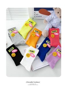 Flat lay of colorful ribbed cotton crew socks with smiley face and letter patches