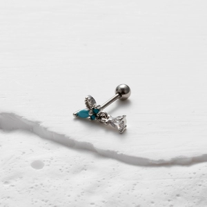 Detail of silver butterfly cartilage stud featuring turquoise stones and clear rhinestones