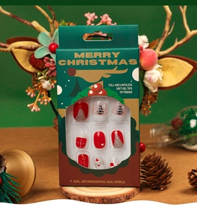 Detailed view of Christmas press-on nails with festive reindeer packaging and berry decor