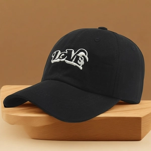 Classic black cotton baseball cap with white LOVE embroidery on a wooden stand