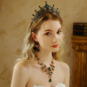 Dettaglio di parure da sposa vintage con pietre verde smeraldo e corona dorata