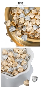Macro detail of gold and silver heart-shaped textured beads with side holes for DIY jewelry